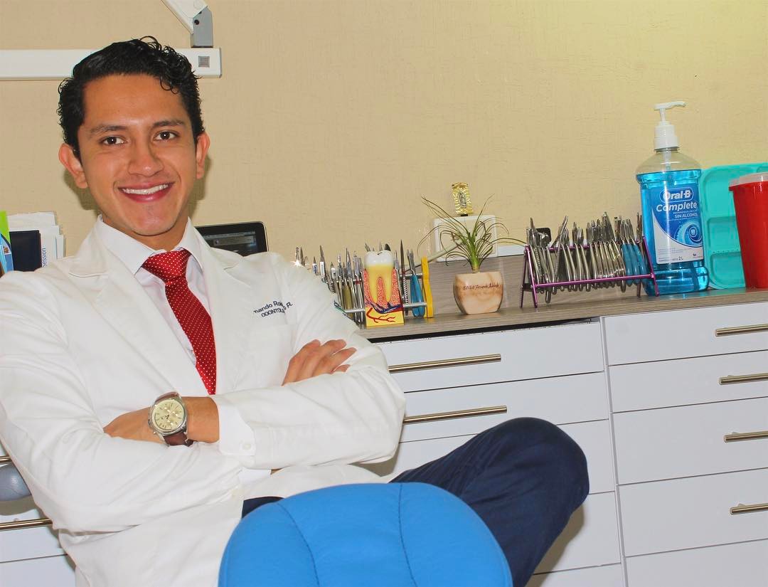 Dr. Fernando Robledo con bata blanca junto al sillón dental